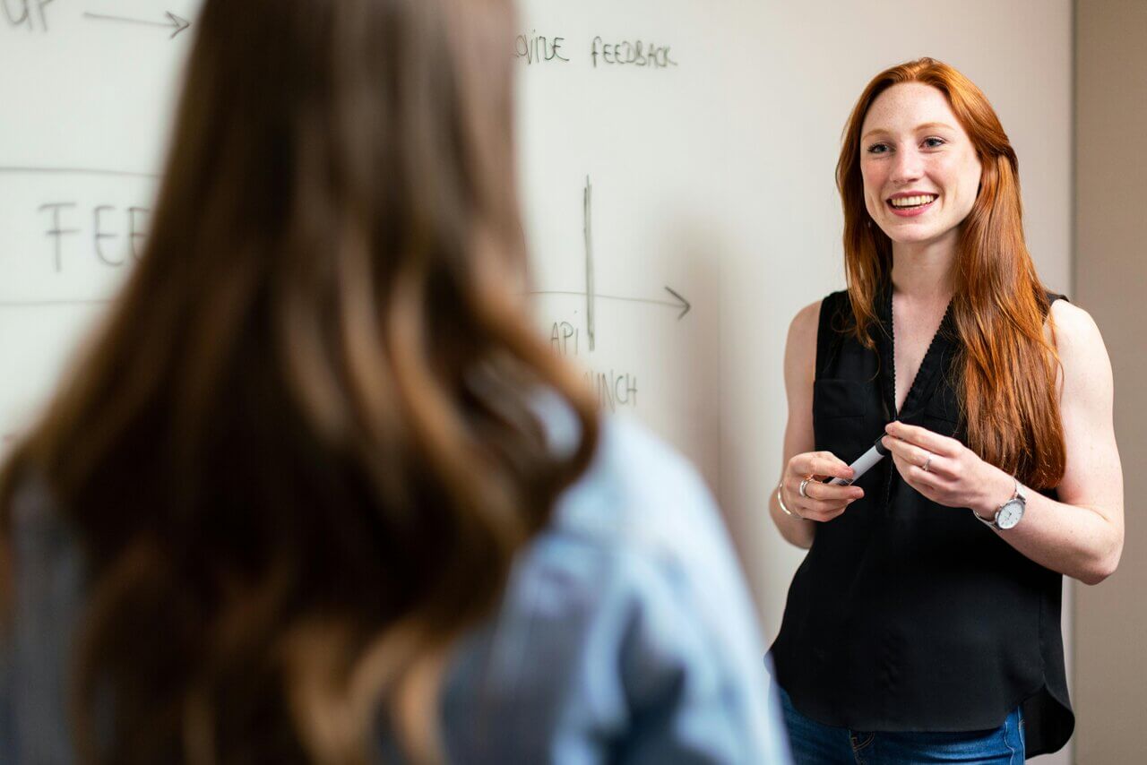 Close up of a young, red-headed female accountant speaking in a meeting