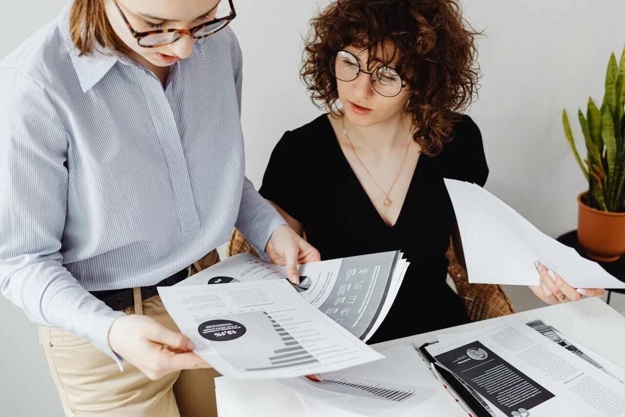 Two female accountants at work reviewing paperwork